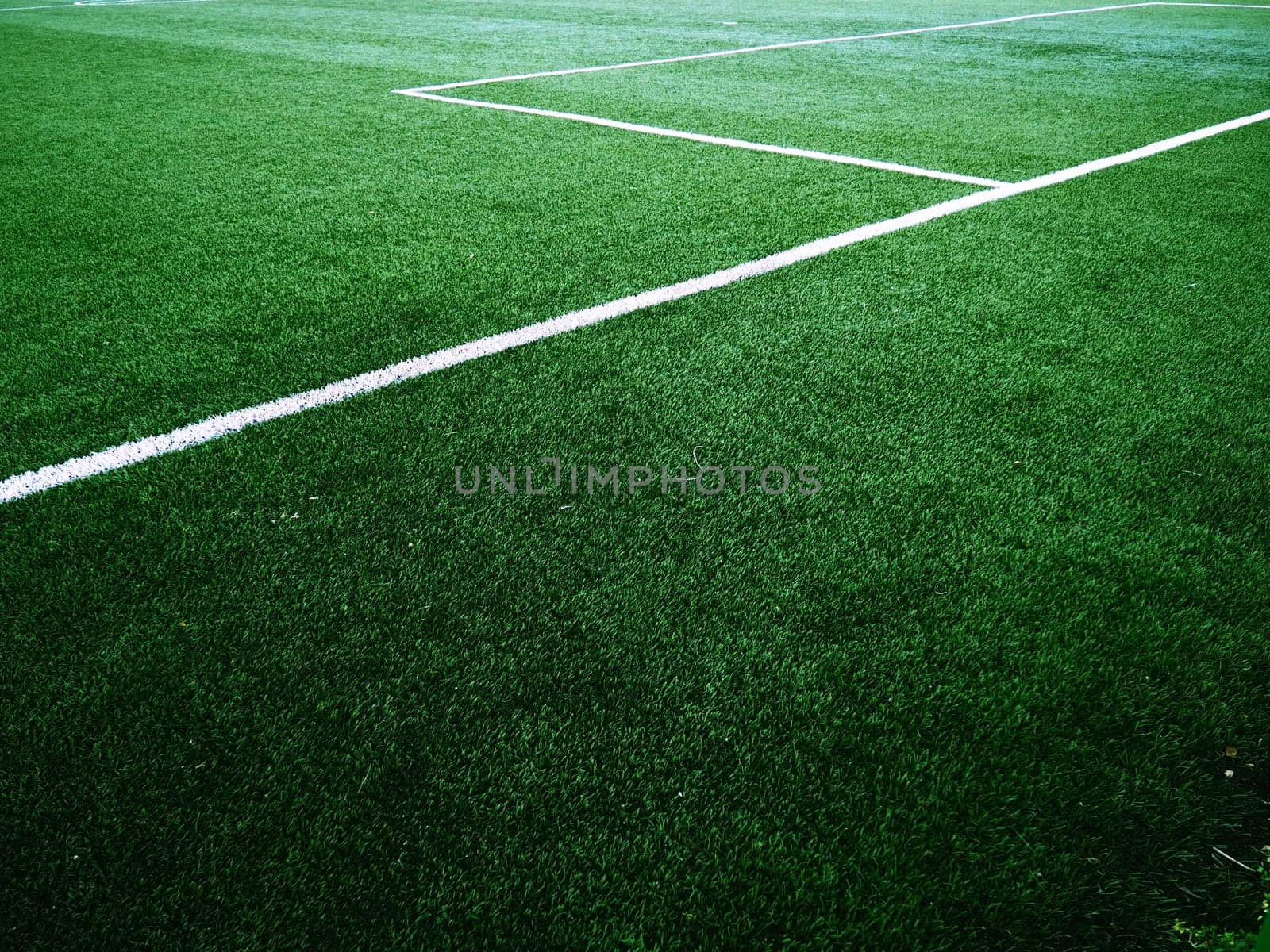 The marking of the football field on the green grass. White lines no more than 12 cm or 5 inches wide. Football field area