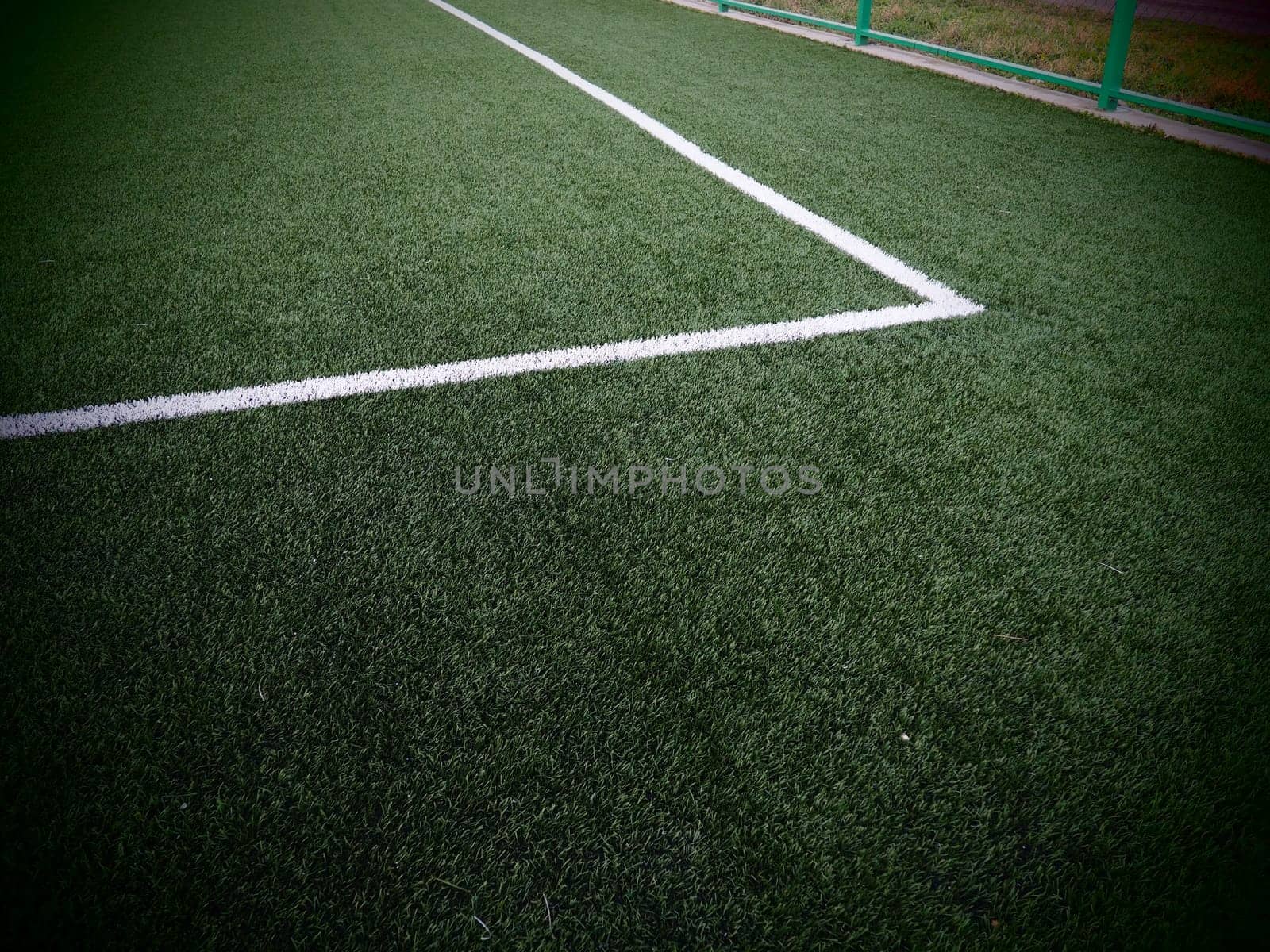 The marking of the football field on the green grass. White lines no more than 12 cm or 5 inches wide. Football field area