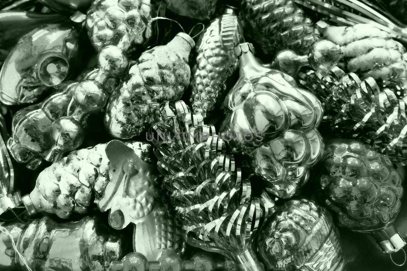 New Year and Christmas tree decorations, glass balls in the form of cones and baskets. Cones and pendants shiny tinsel. Festive Christmas decorations. Black and white monochrome. Green tint