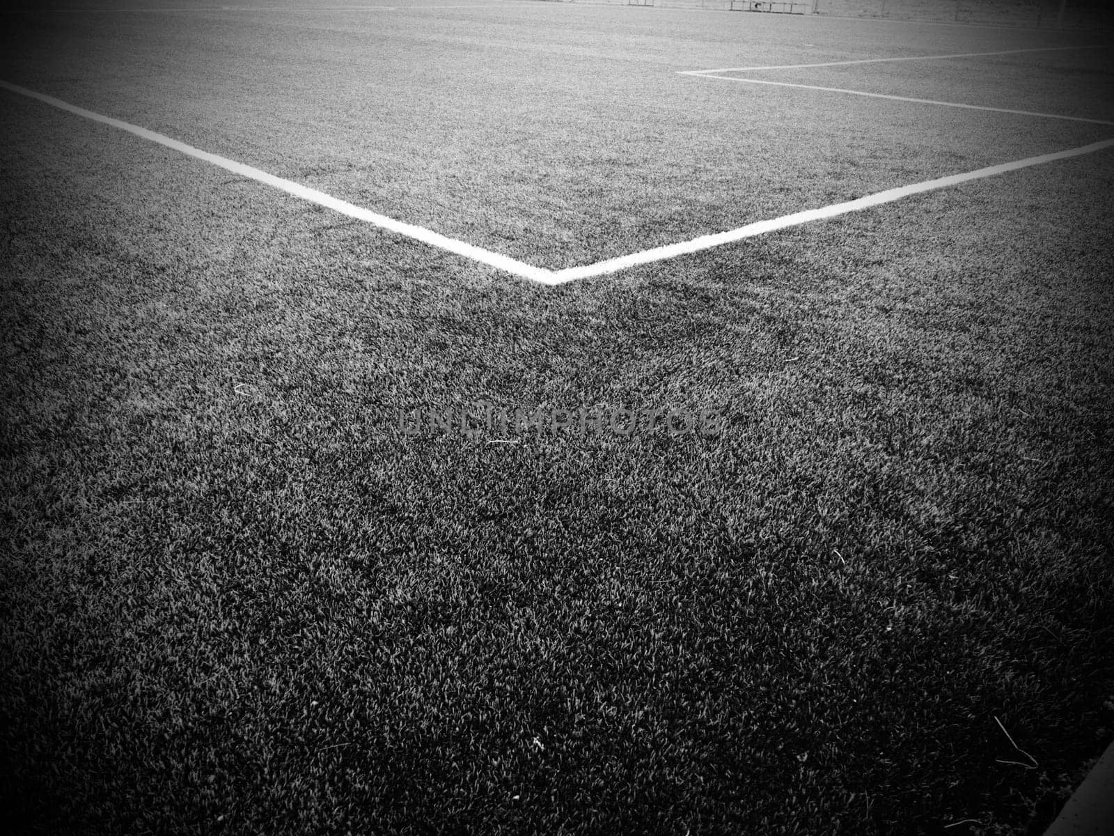 The marking of the football field. White lines no more than 12 cm or 5 inches wide. Football field area. Black and white monochrome photography.