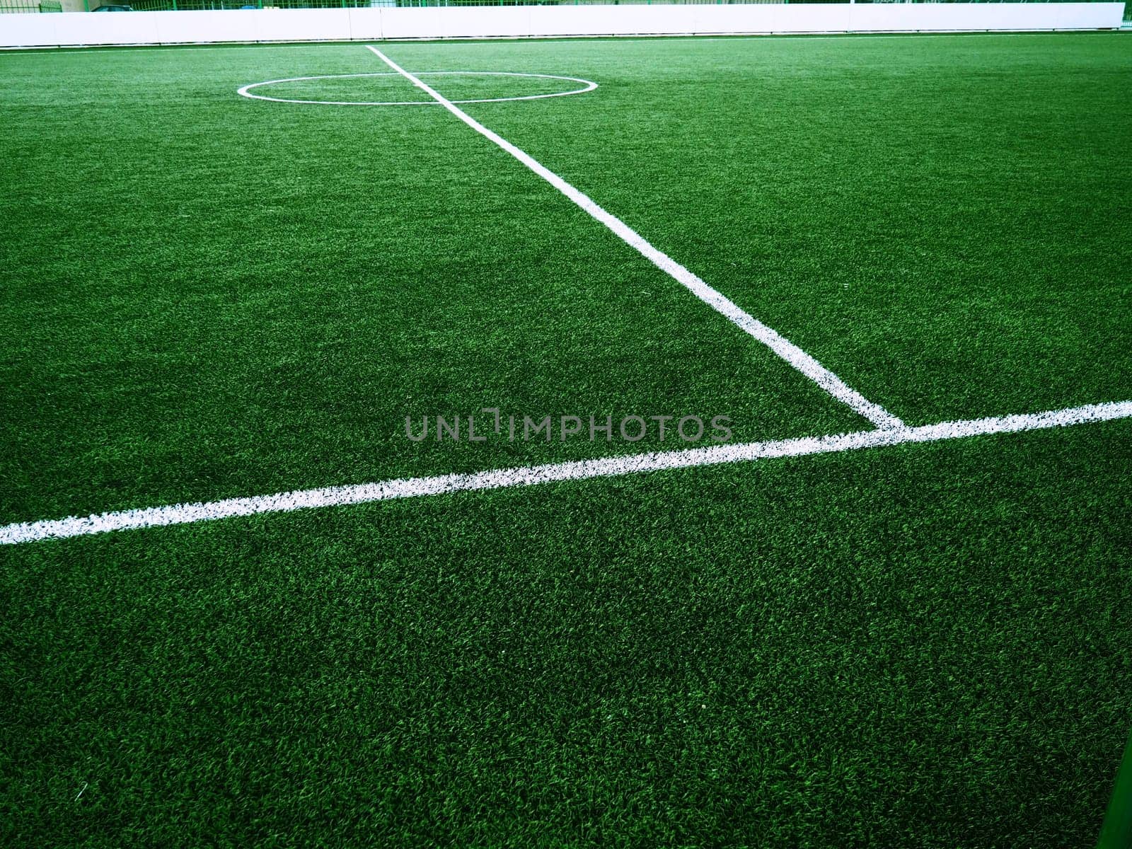 The marking of the football field on the green grass. White lines no more than 12 cm or 5 inches wide. Football field area