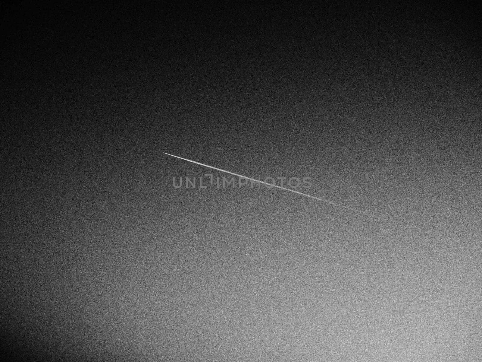 the plane and the trail in the sky is black or gray. Abstract background on a space or aero theme. Increased graininess. Light gradient.