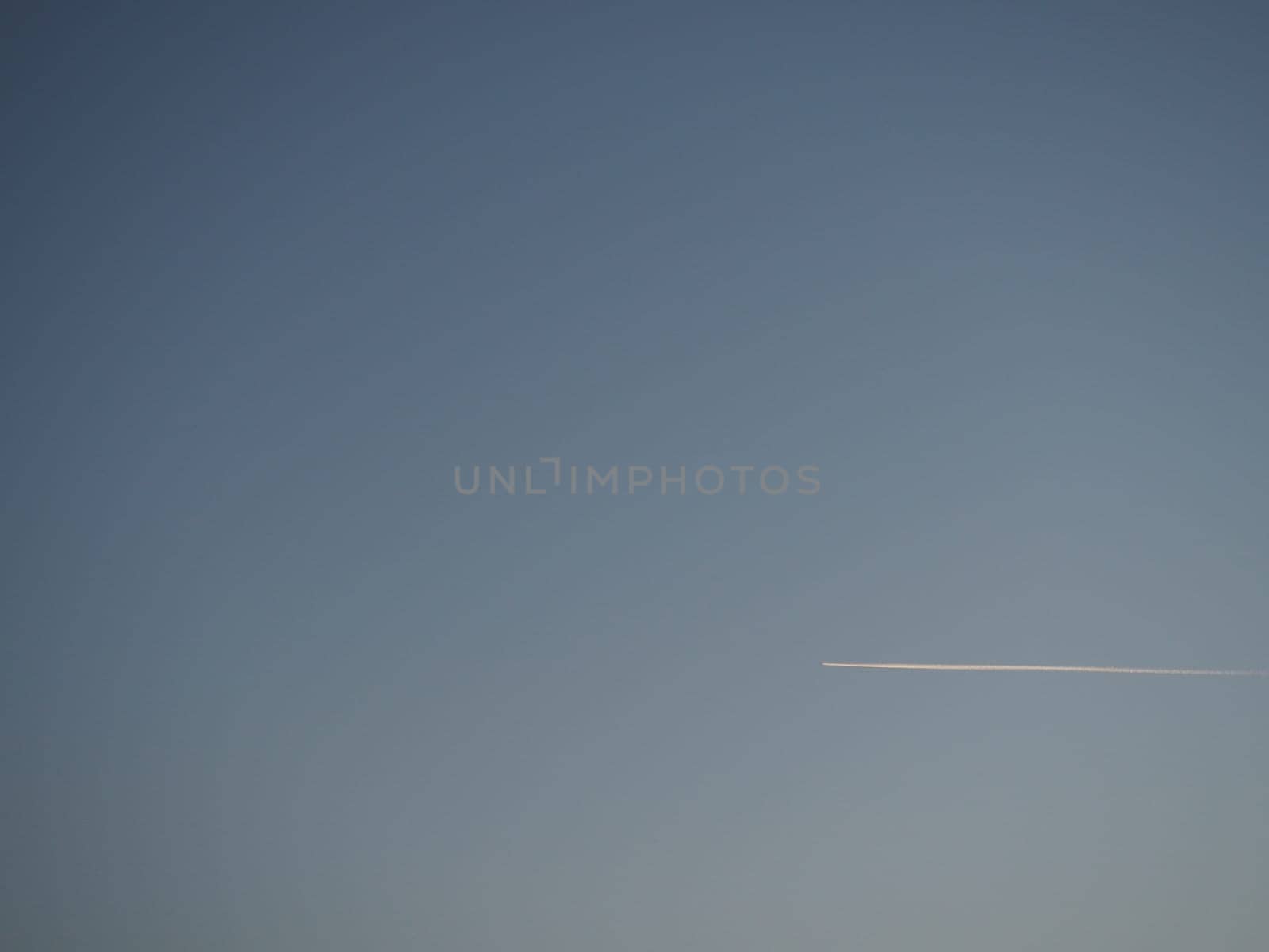 plane and trail in the evening sky blue. Abstract background on a space or aero theme. Color gradient.