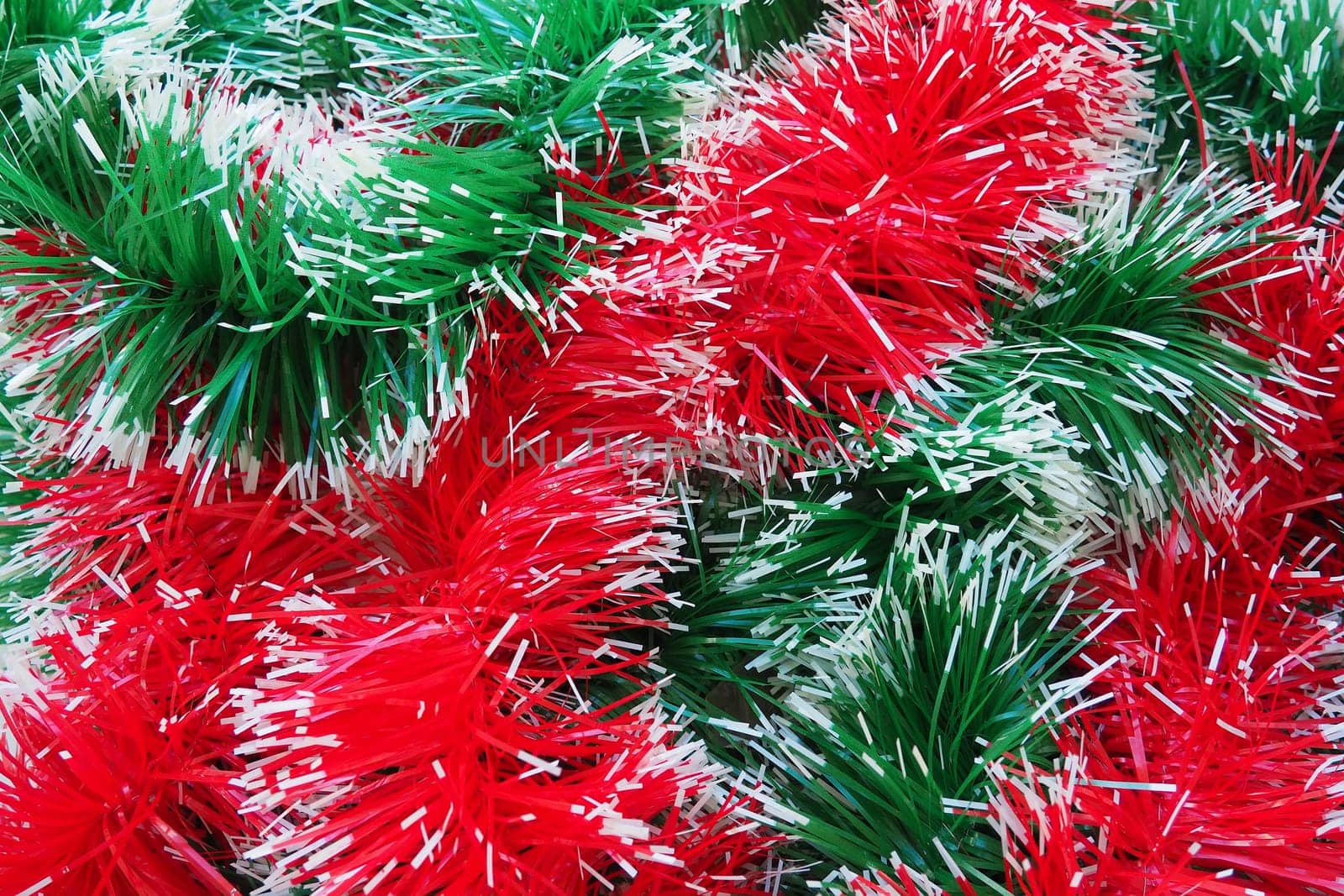 New Year and Christmas decorations, red and green boas for the Christmas tree. Two-color Christmas rain garlands are mixed. Festive decor