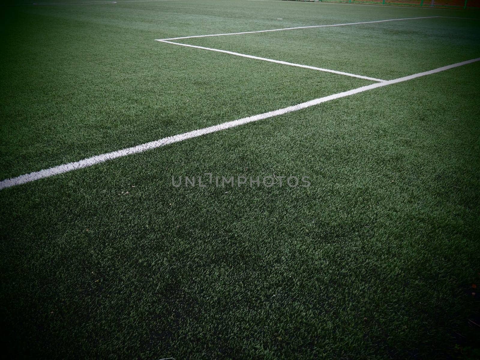 The marking of the football field on the green grass. White lines no more than 12 cm or 5 inches wide. Football field area