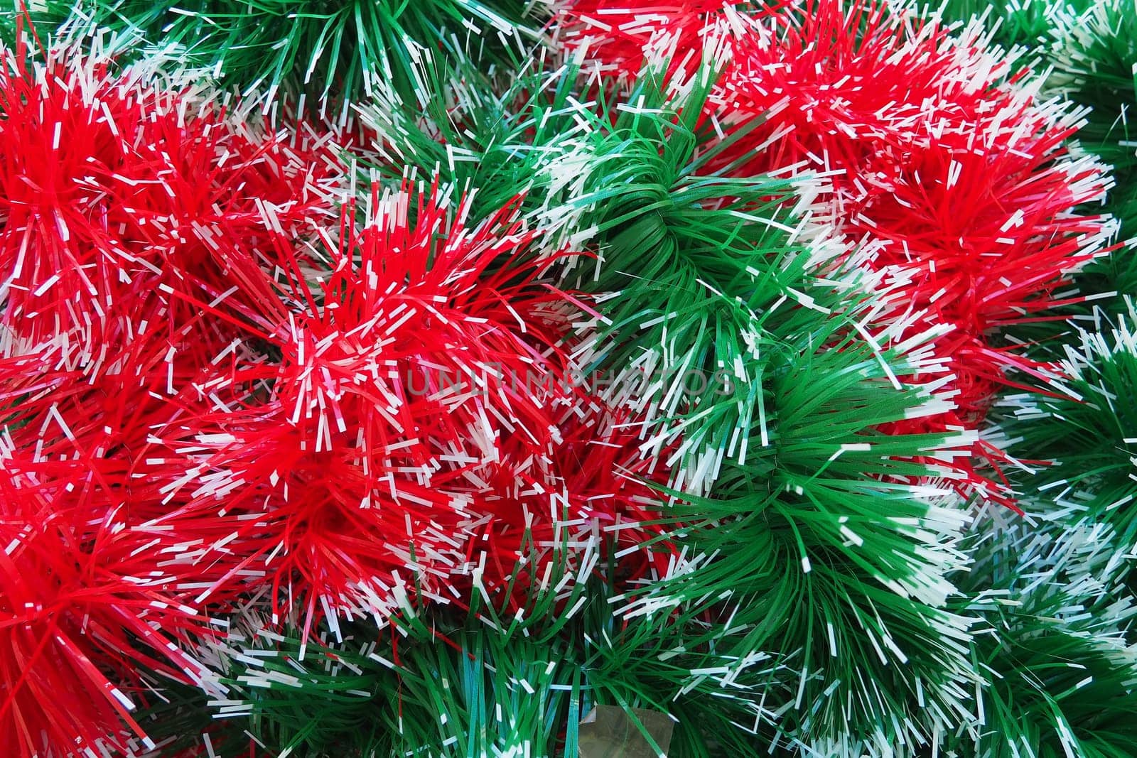 New Year and Christmas decorations, red and green boas for the Christmas tree. Two-color Christmas rain garlands are mixed. Festive decor