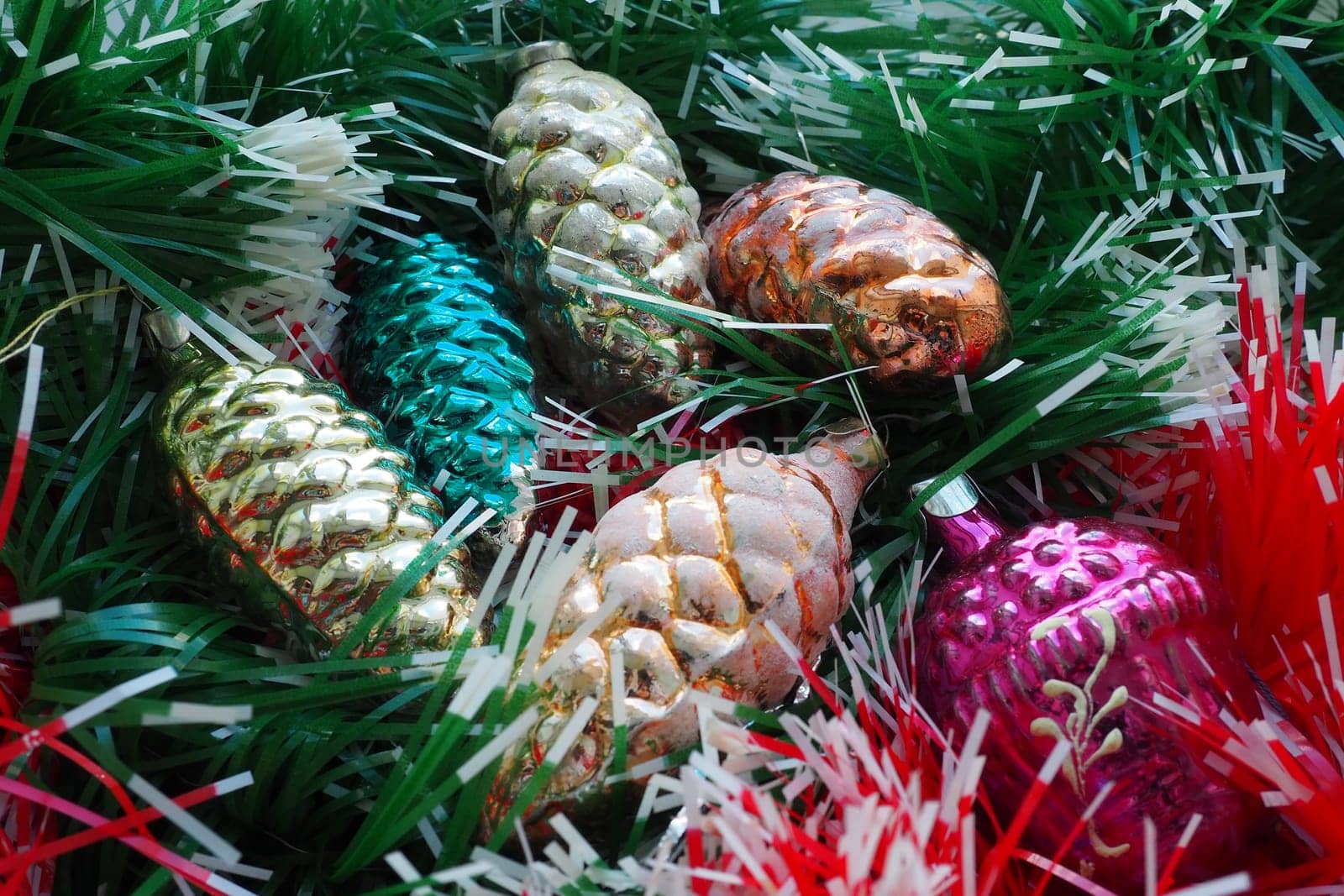 New Year and Christmas tree decorations, glass balls in the form of cones and baskets. Cones and pendants made of shiny tinsel. Festive background postcard layout blank. Lots of Christmas decorations