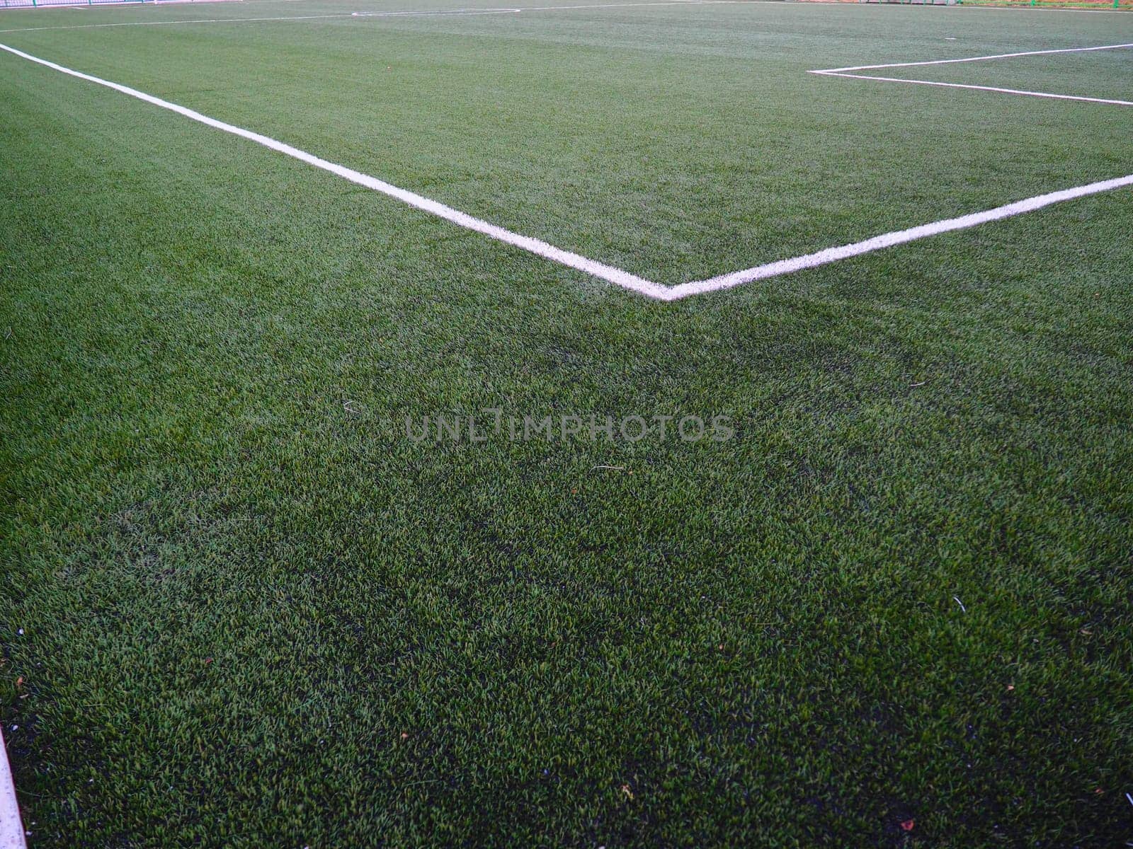 The marking of the football field on the green grass. White lines no more than 12 cm or 5 inches wide. Football field area
