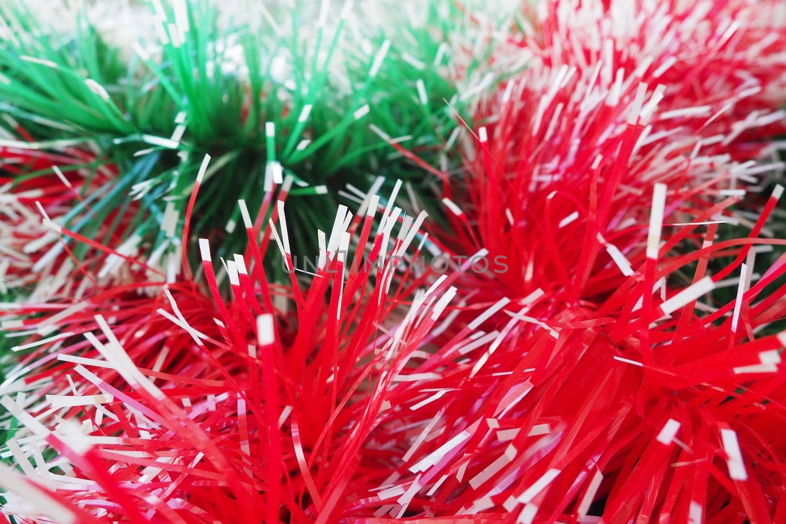 New Year and Christmas decorations, red and green boas for the Christmas tree. Two-color Christmas rain garlands are mixed. Festive decor