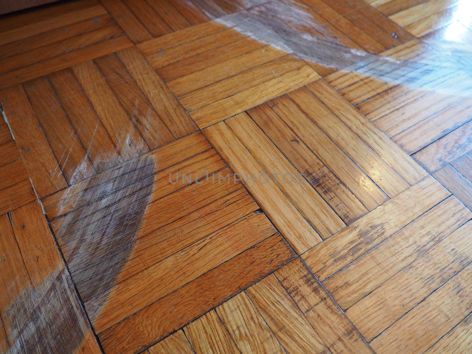 Scratched parquet flooring in the room. Scratches, chips and dents on the floor. Parquet in need of repair