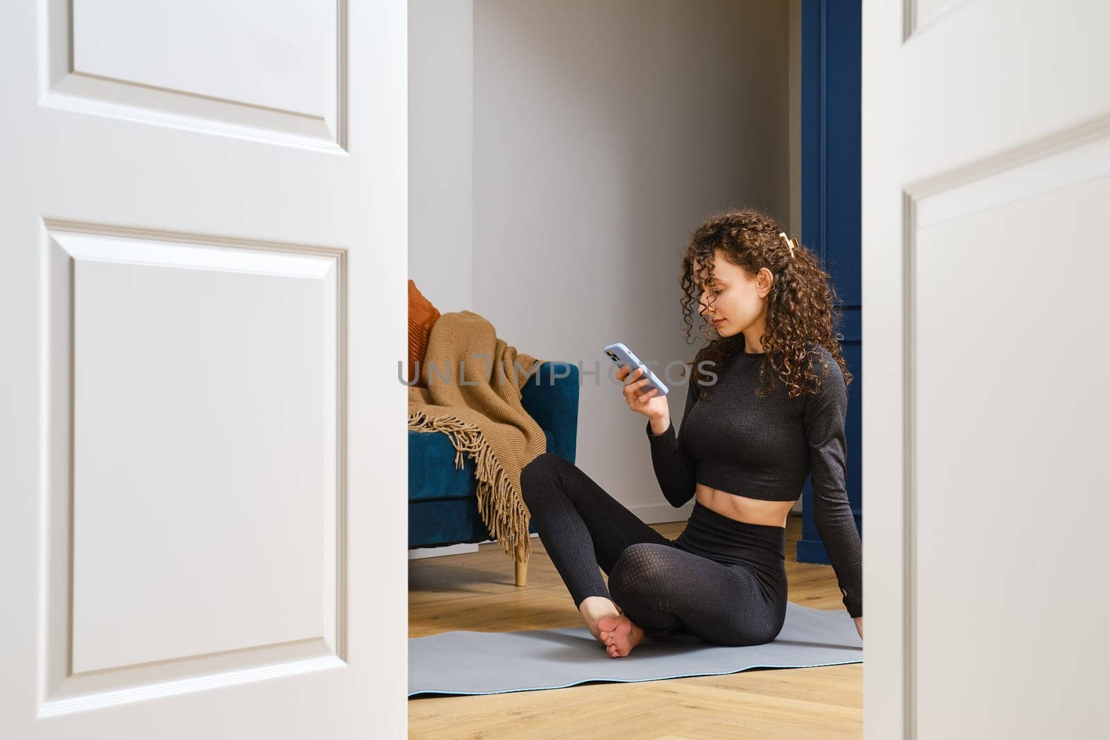 A young woman was doing sports at home, but was distracted by a message in the messenger. Addiction to social network of millennials.