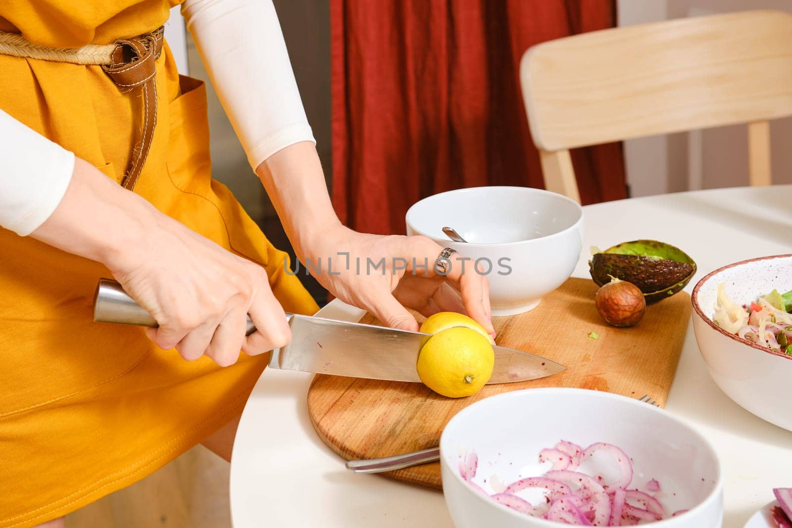 Unrecognizable woman cutting lemon for vegetarian salad