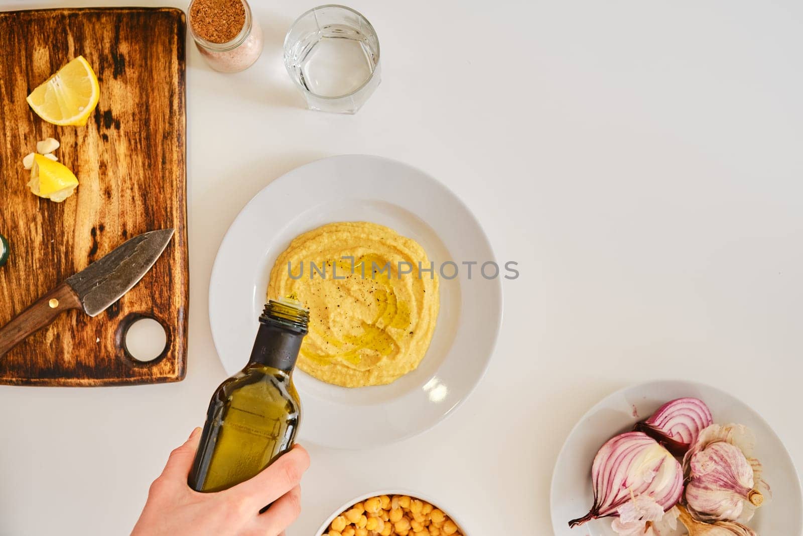 Adding olive oil to hummus, top view