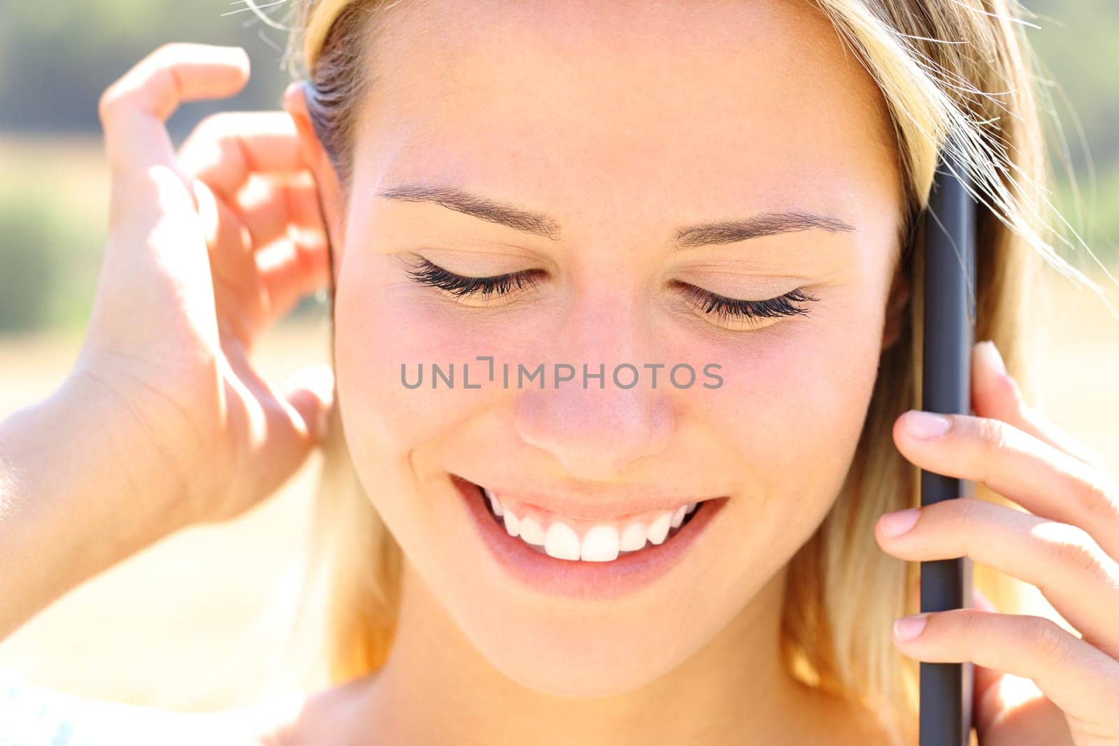 Happy teen talks on phone outdoors