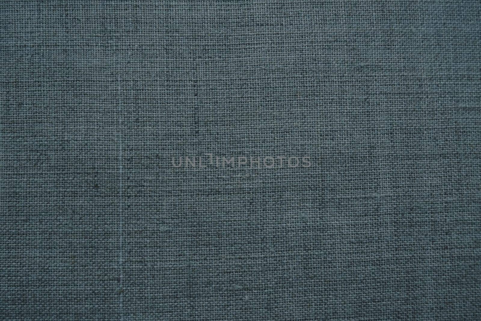 Fabric texture background. Dark gray fabric with weave. Natural slightly wrinkled look of the material. Uniform copy space background. Cotton, canvas or woolen thin fabric laid evenly on the surface