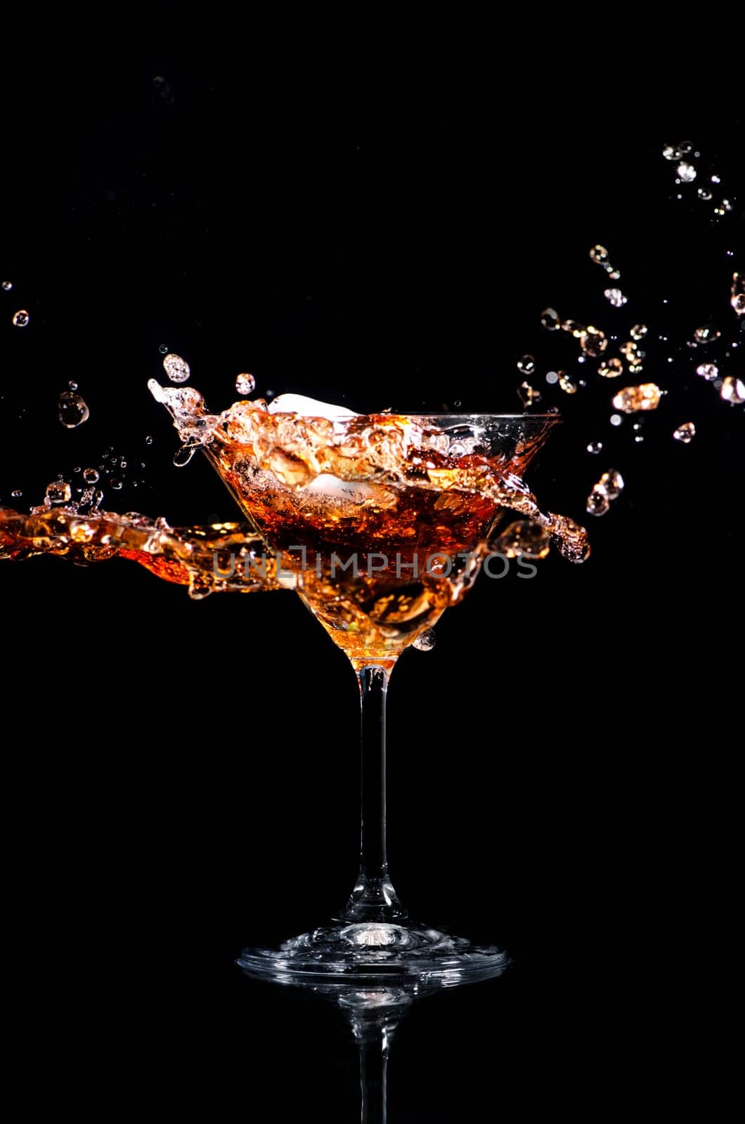 Martini cocktail splash over black background. Cocktail happy hour and night club party concept.