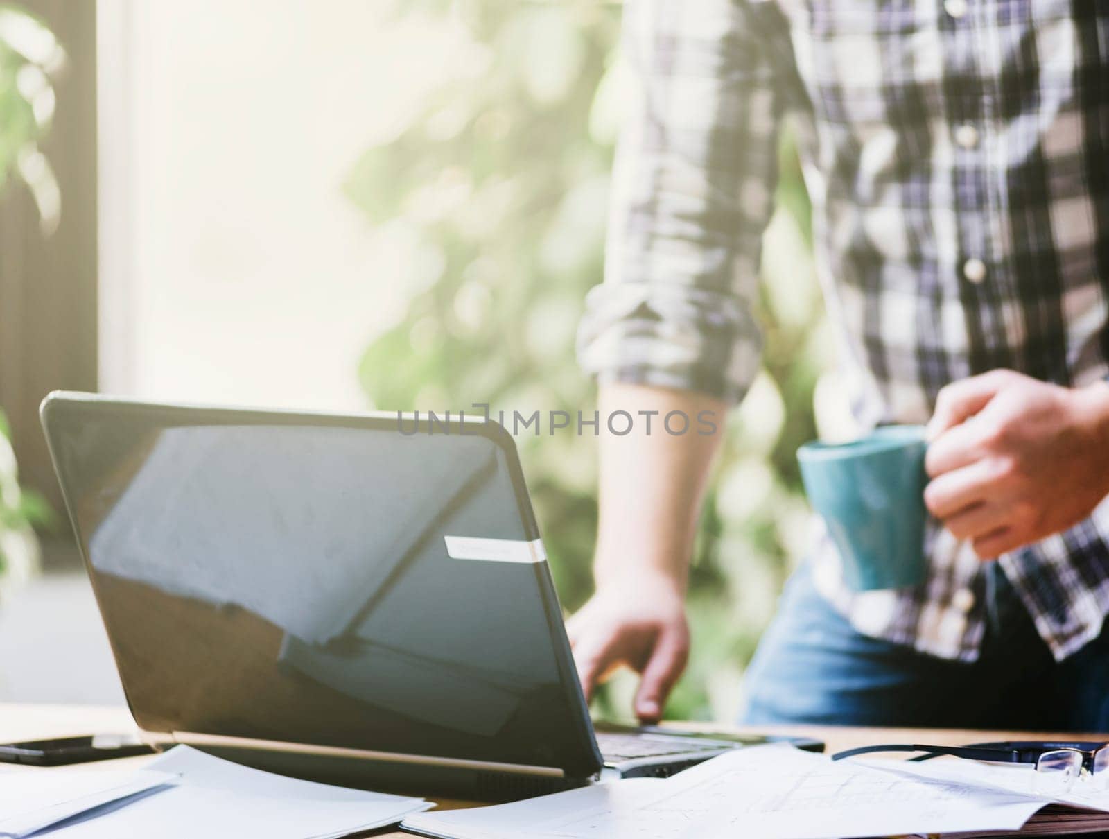 Closeup of business man work on computer in his pleasant studio home office. Freelance professions in cool workplace environment: programmer, designer, architect, blogger, entrepreneur, social media...