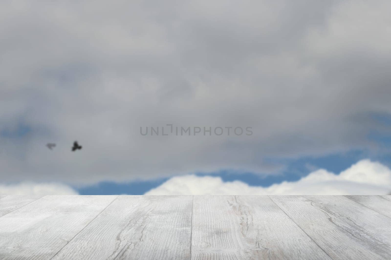 Empty wooden table with abstract blurred natural cloudy blue sky background. Space for your food and product display montage.