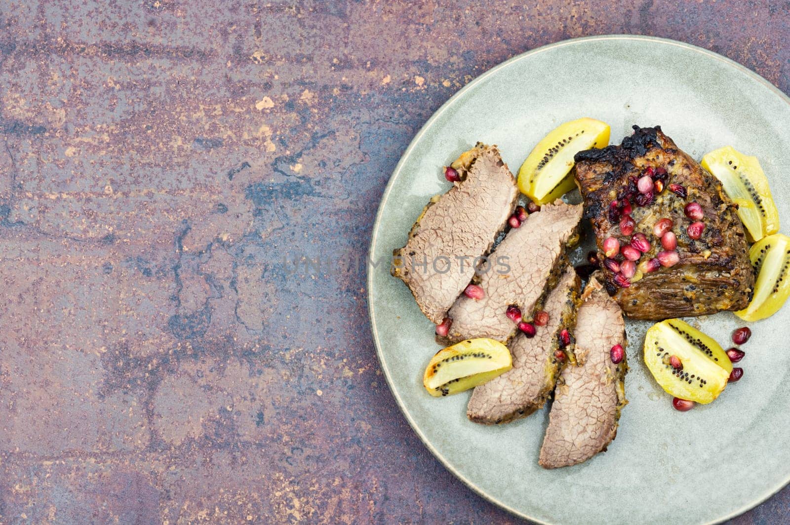 Stewed veal meat in kiwi and pomegranate sauce.