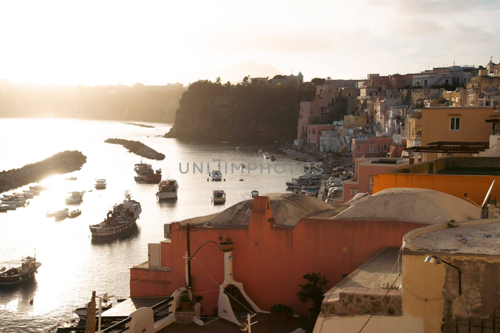 View of the Port of Corricella with lots of colorful houses on a sunny day in Procida Island, Italy.