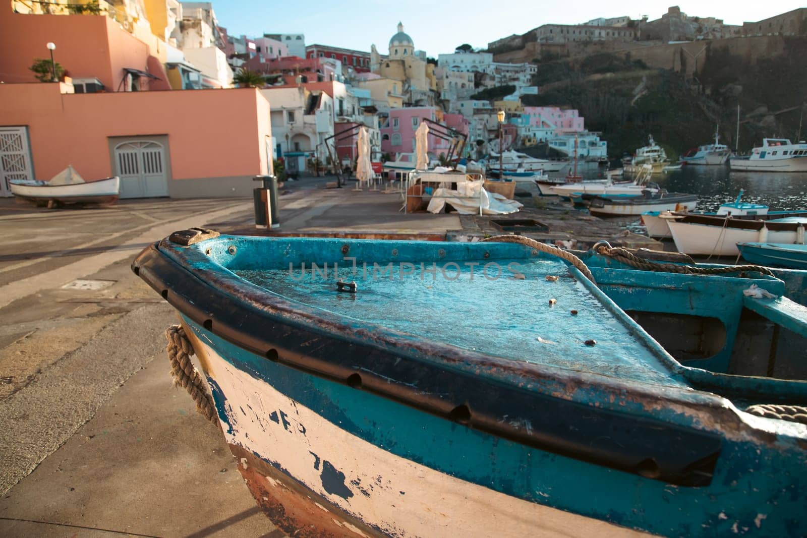 View of the Port of Corricella with lots of colorful houses on a sunny day in Procida Island, Italy.