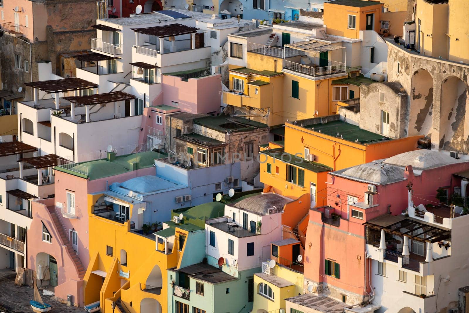 View of the Port of Corricella with lots of colorful houses in the sunset, Procida Island, Italy.