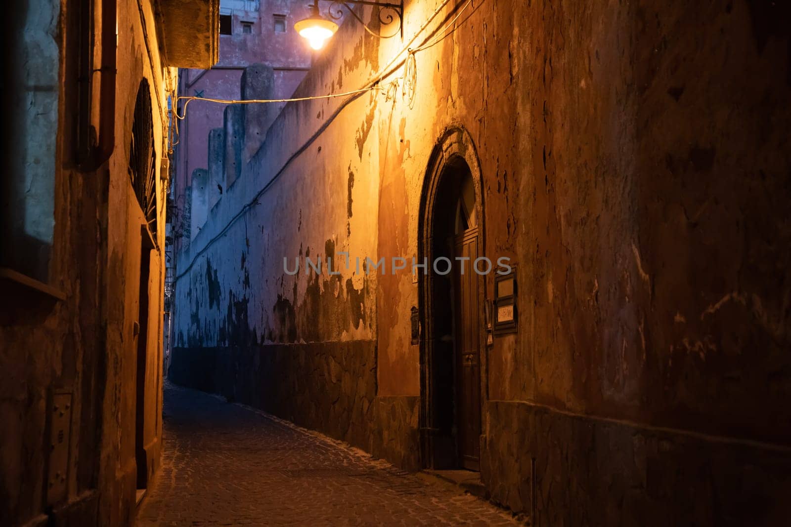 Tiny narrow streets with colorful houses at night on Procida Island, Italy.