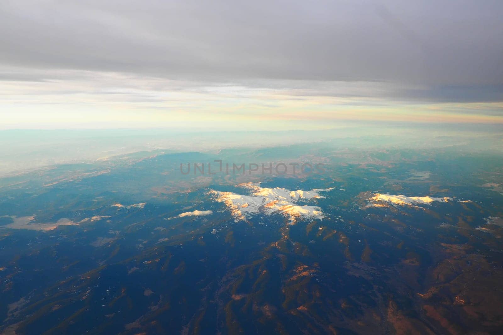 Turkey, Ankara. View from airplane window to the Turkish mountains, lakes and snowy peaks. Layered clouds and horizon. Lakes Saryar, Nallihan and Camlidere. Departure from Esenboga Havalimani Airport.