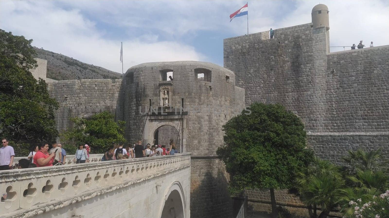 Pile Gate Dubrovnik Croatia August 14 2022 People men and women walk along the stone bridge to the gate of the Old City. Crowd of tourists. Busy entrance. The main entrance to Old Town, busy Pile Gate