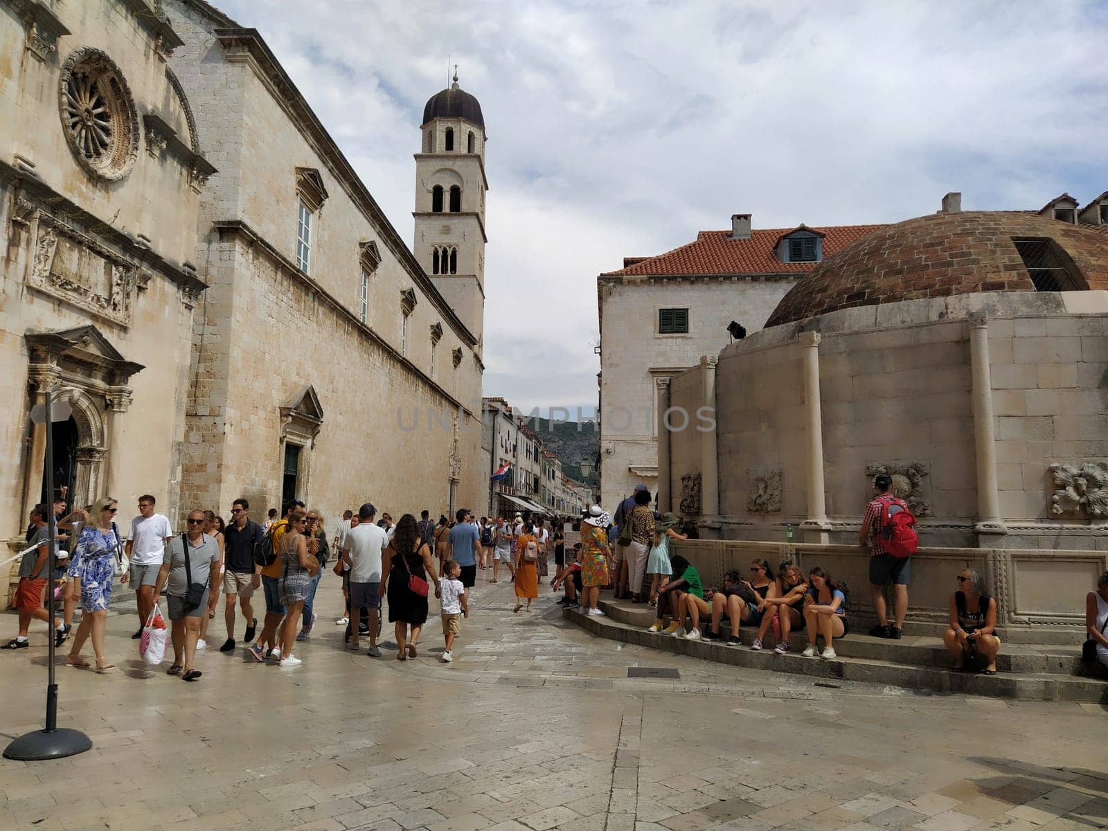 Big Onofrio Fountain, Velika Onofrijeva chesma, Dubrovnik, Croatia. Water supply established during the Quattrocento period. Numerous multinational happy tourists walk on the Stradun 14 August 2022.