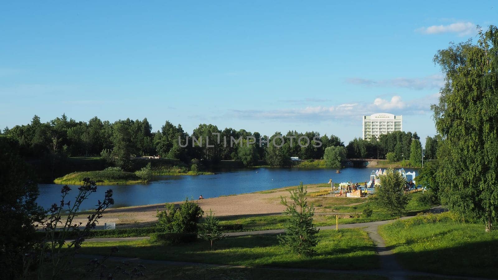 Mouth, floodplain and terraces of the Lososinka River, Petrozavodsk, Republic of Karelia August 3, 2022. Sunny windless evening. City sandy beach. Passers-by people with children walk. Hotel Karelia.