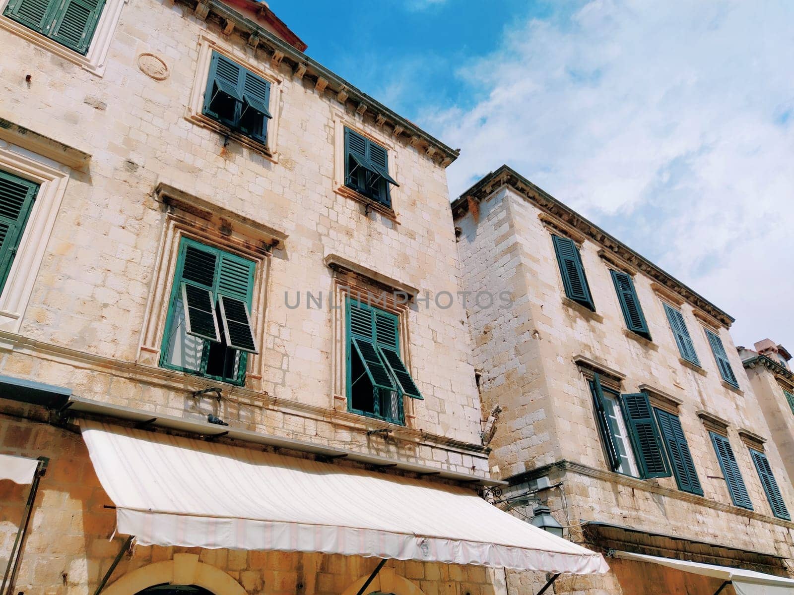 Stradun, Stradone is the main street of the historic city center of Dubrovnik in Croatia. Architectural sights. The facade of the building with green metal shutters on the windows. August 14, 2022.