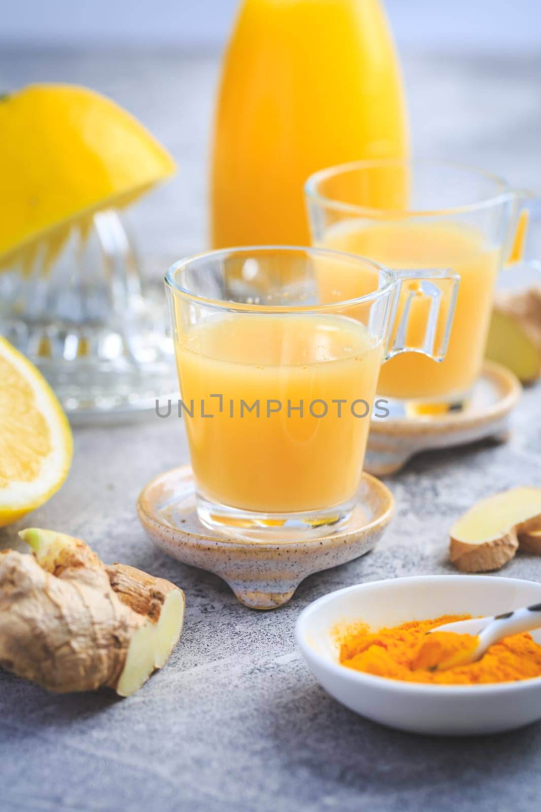 Homemade turmeric lemon ginger shots in small glasses, healthy Ginger Lemon Turmeric Shot – ideal to boost the immune system during the winter