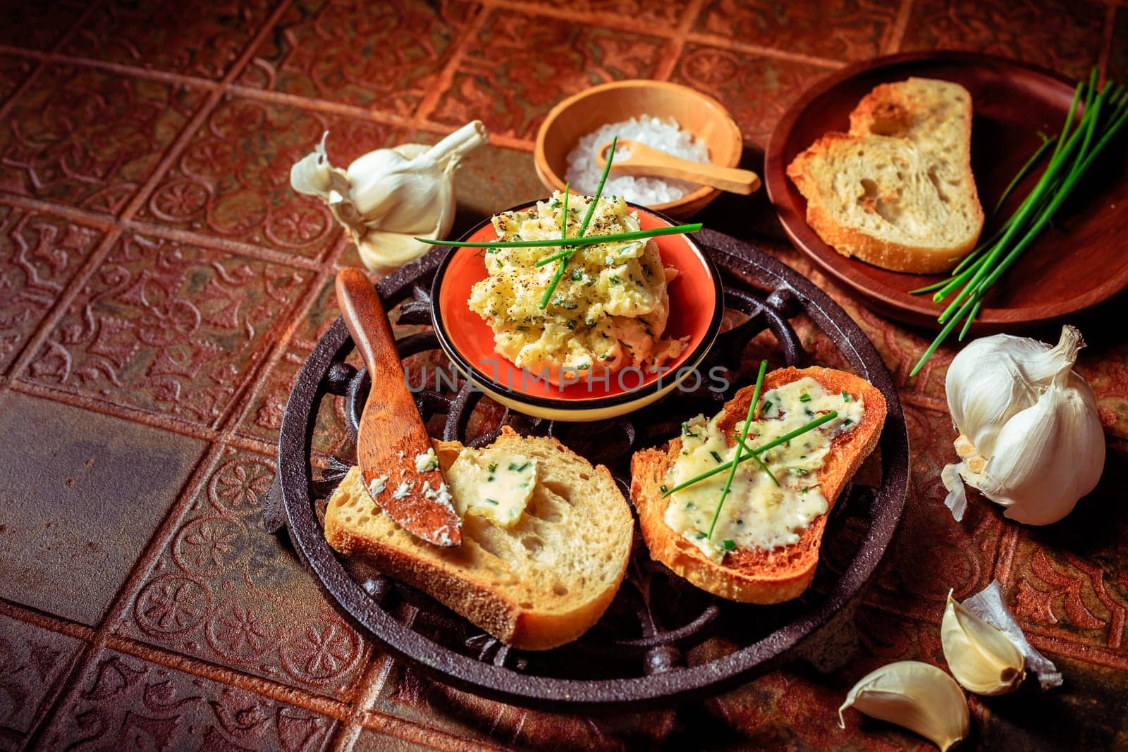 Homemade garlic bread or baguette slices with garlic butter and herbs on kitchen table