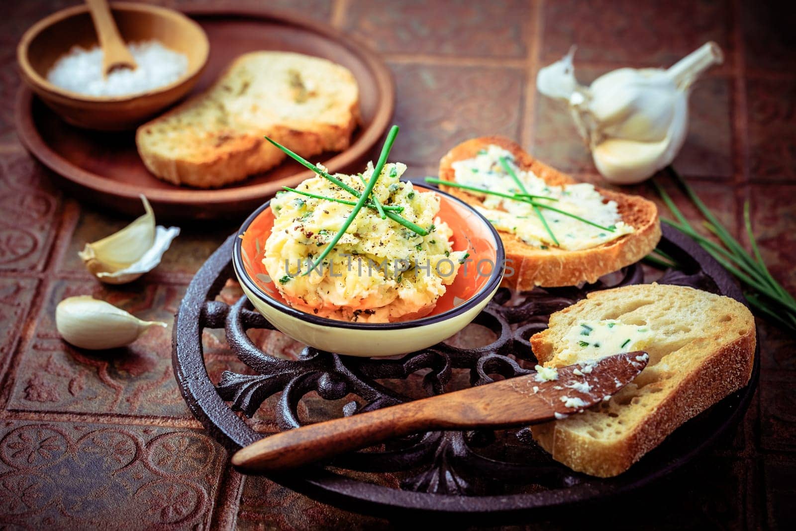 Homemade garlic bread or baguette slices with garlic butter and herbs on kitchen table