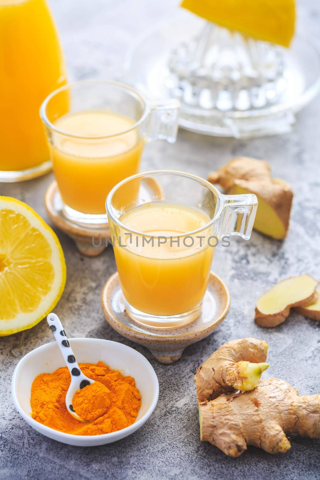 Homemade turmeric lemon ginger shots in small glasses, healthy Ginger Lemon Turmeric Shot – ideal to boost the immune system during the winter
