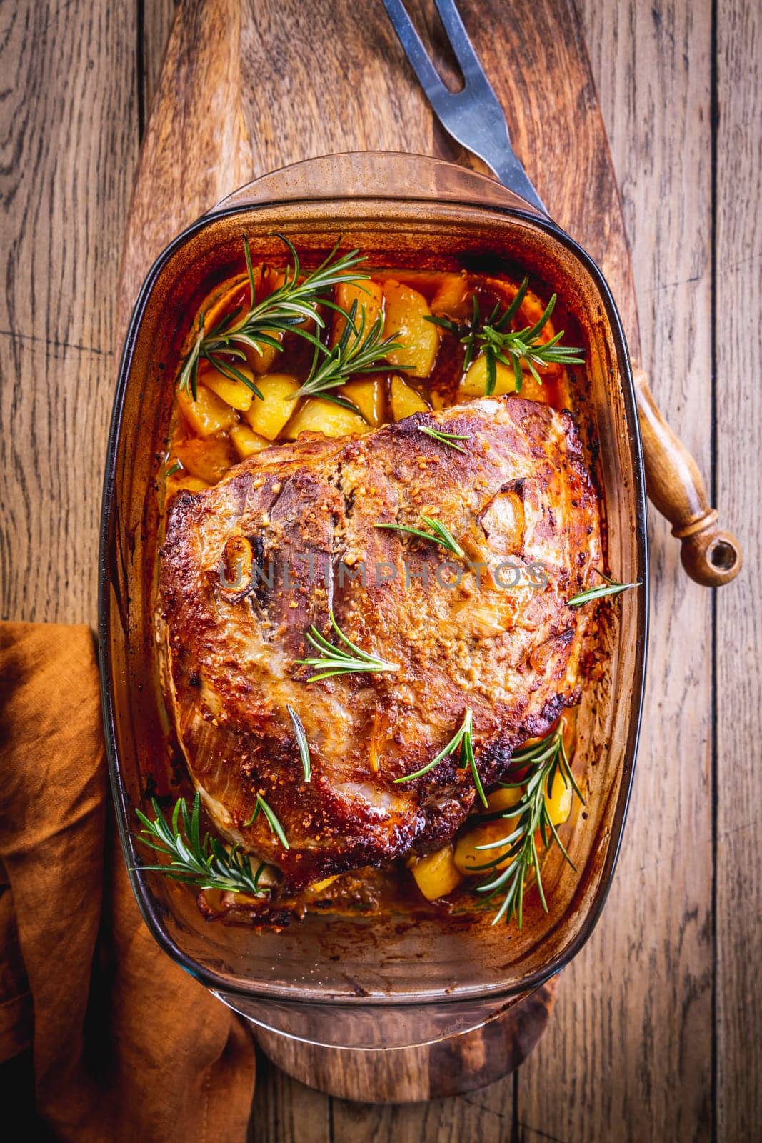 Roasted pork meat with potatoes, rosemary and beer sauce in casserole