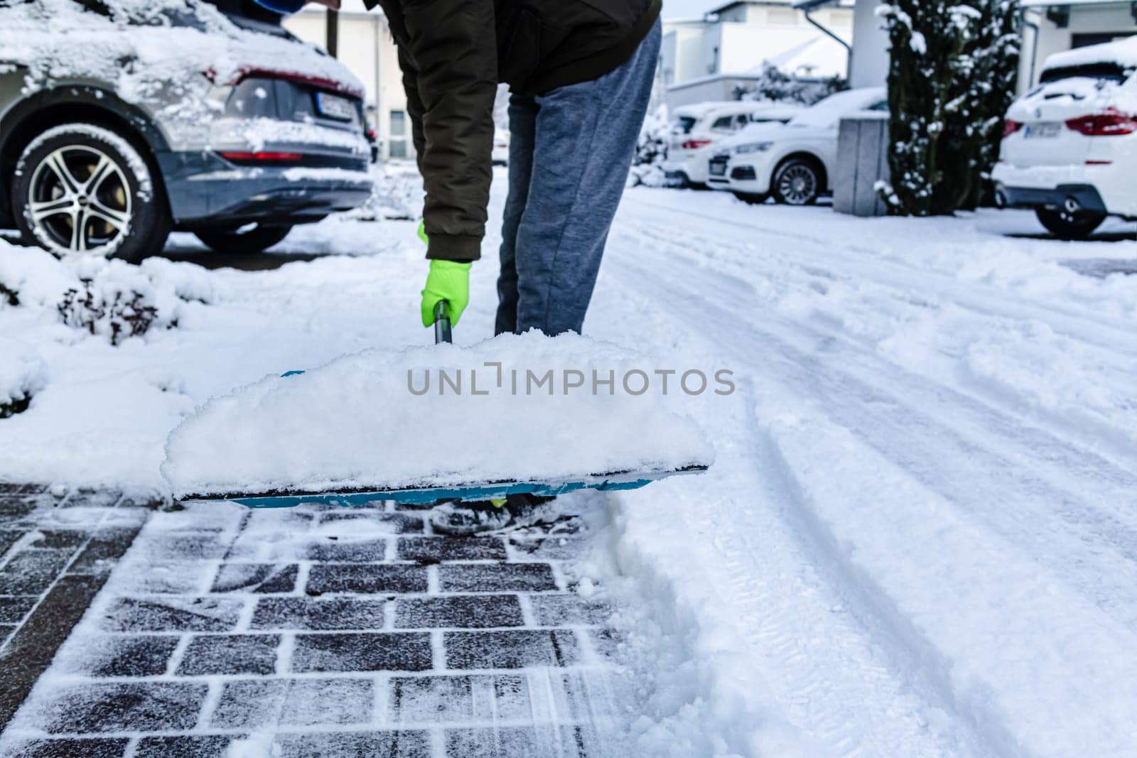 Teenager shoveling snow outdoors on winter day, closeup