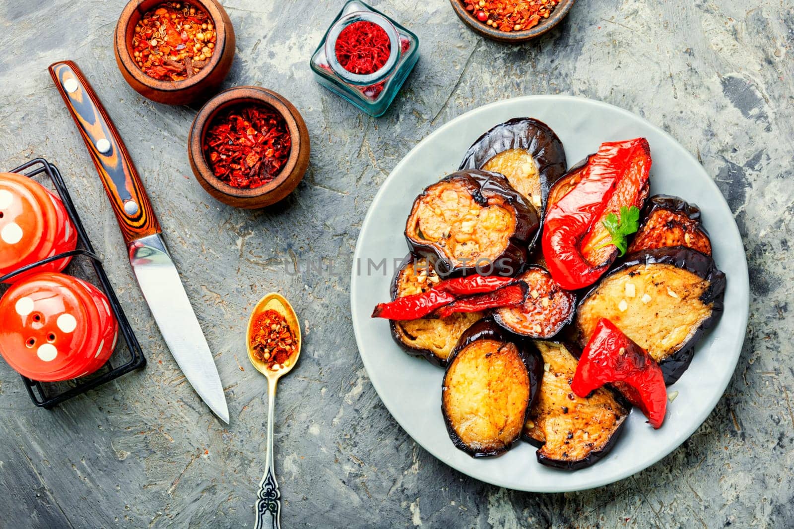Grilled eggplant and grilled bell pepper on stone or concrete background