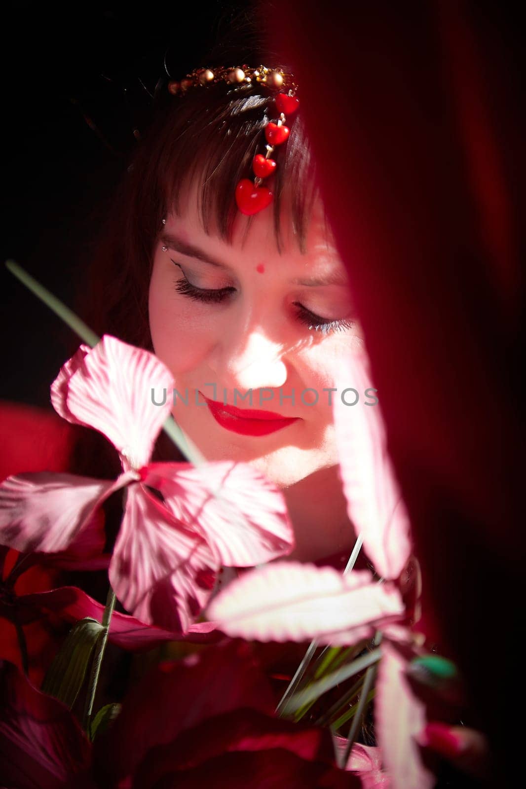 Woman dressed in a vibrant sari poses elegantly among flowers, capturing the beauty of Indian culture in a captivating photoshoot.