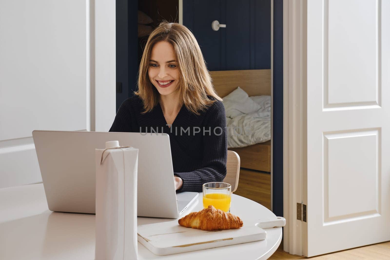 Happy smiling woman chatting online from home using laptop