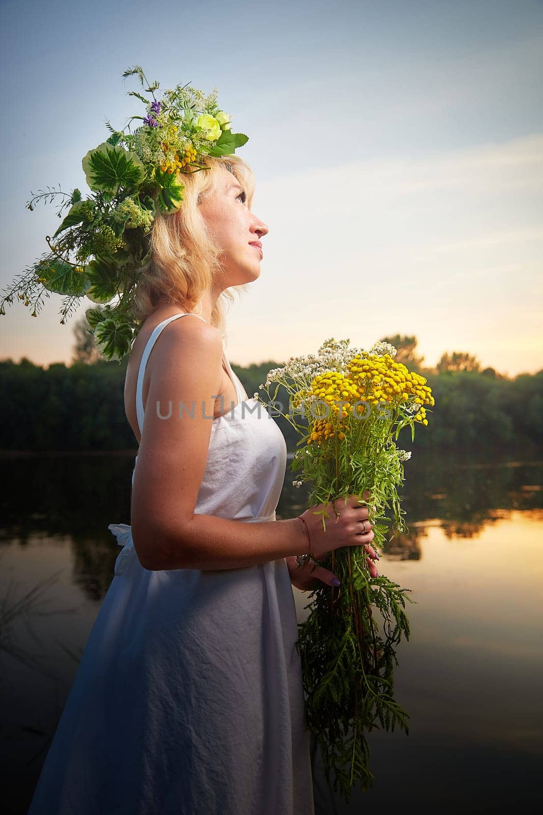 Girl in White Sundress With Flower Wreath by Water at Sunset Celebrating Ivan Kupala Holiday