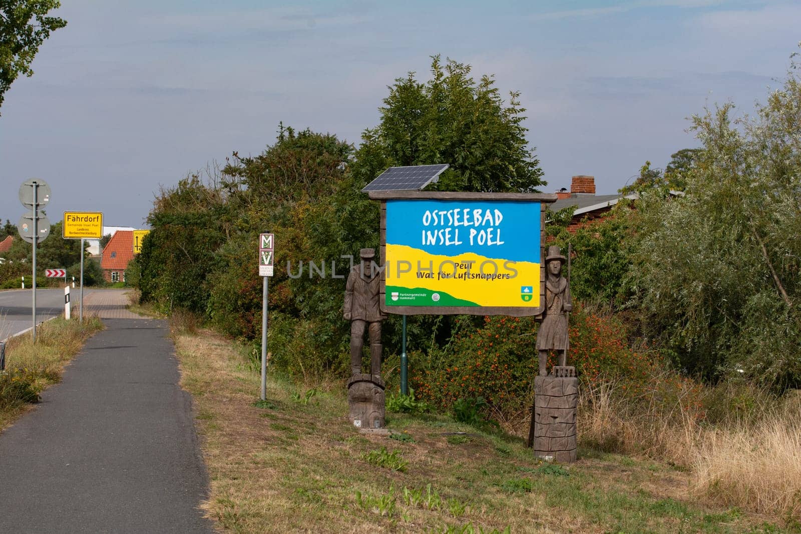 Insel Poel, Germany, September 9, 2022 - Wooden figures with welcome sign to the Insel Poel in Mecklenburg-Vorpommern, Germany