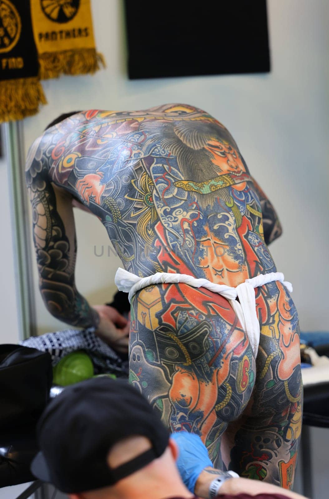 Krakow, Poland -  June 11, 2022: Unidentified  participant at 15th Tattoofest Convention in Cracow. One of the most prestigious tattoo festivals. Tattoo artist at work.