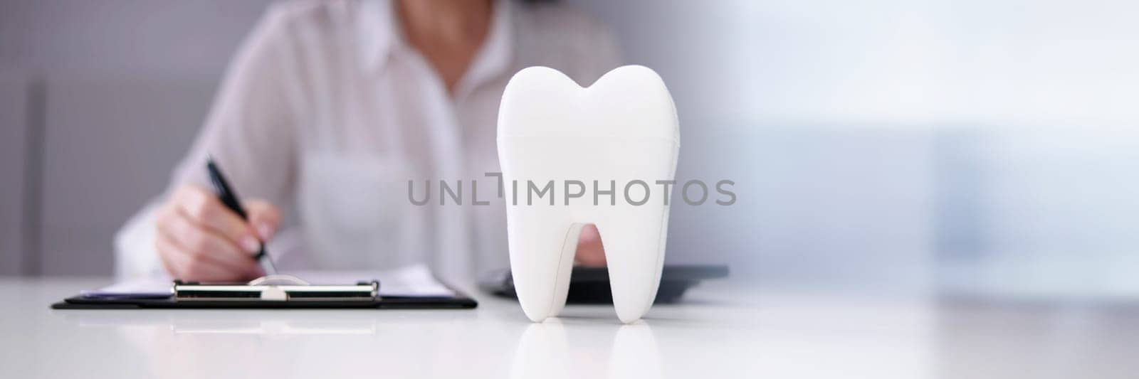 Dentist Paperwork At Desk In Front Of Teeth