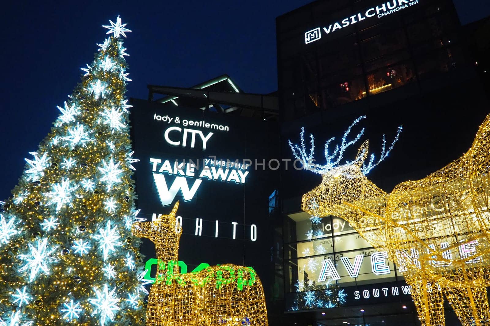 Moscow, Russia, January 17 2023 Street Christmas tree with snowflakes and festive balls. Metro Yugo-Zapadnaya. Christmas decorations in front of the mall. Silver stars, snowflakes and golden deers.