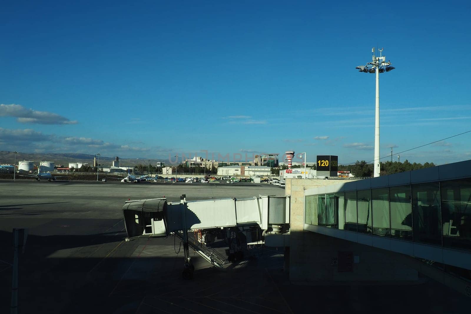 Ankara, Turkey, Esenboga Havalimani airport, 01.19. 2023 View from the window of the passenger terminal on the runway area. Airplane bridge. Tower with antenna. Airport building, boarding gate. Clouds