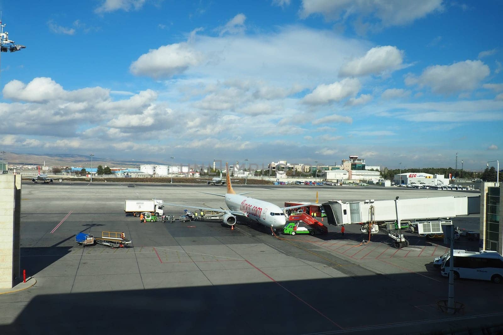 Ankara, Turkey, Esenboga Havalimani Airport, 01.19.2023. view from the window of the passenger terminal on the runway area. Airplane bridge. Passengers with suitcases disembark from the plane. Clouds