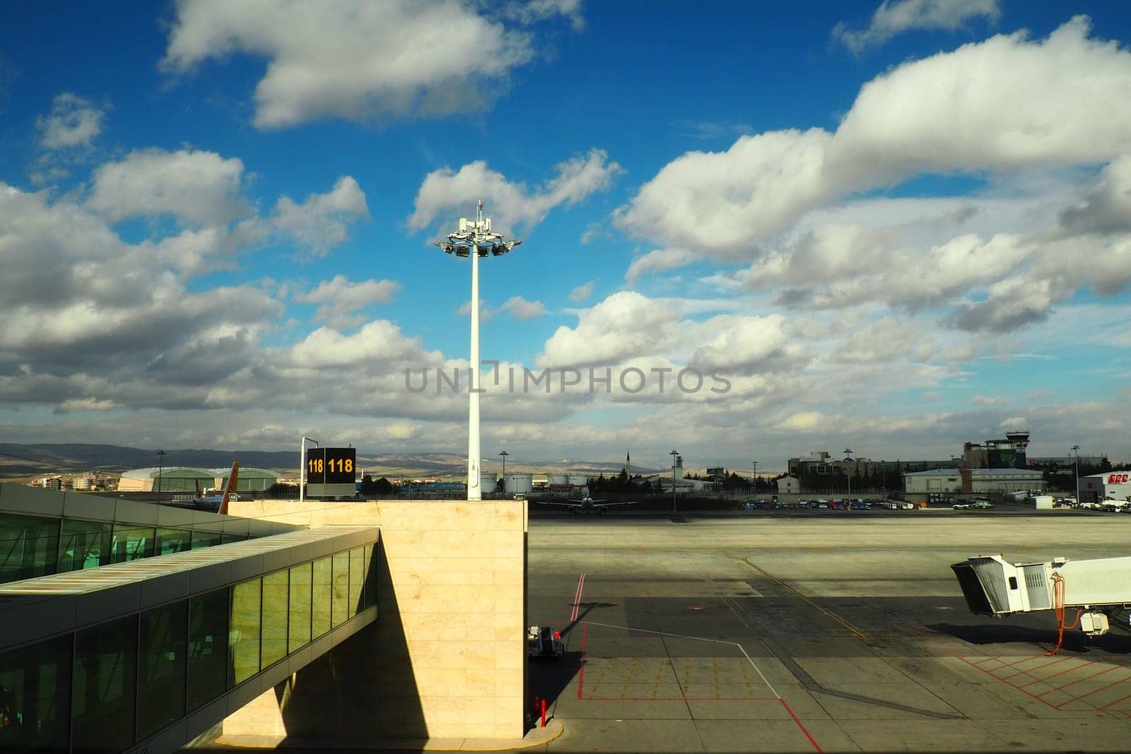 Ankara, Turkey, Esenboga Havalimani airport, 01.19. 2023 View from the window of the passenger terminal on the runway area. Airplane bridge. Tower with antenna. Airport building, boarding gate. Clouds
