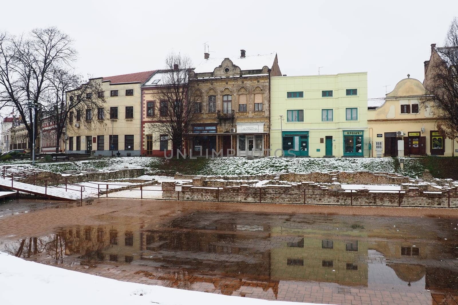 Sremska Mitrovica Serbia 01.27.2023 Snowfall in the city. Zhitni trg historical square. Ancient multi-colored buildings and excavations of Roman times. Weather forecast. Day winter. Cultural heritage